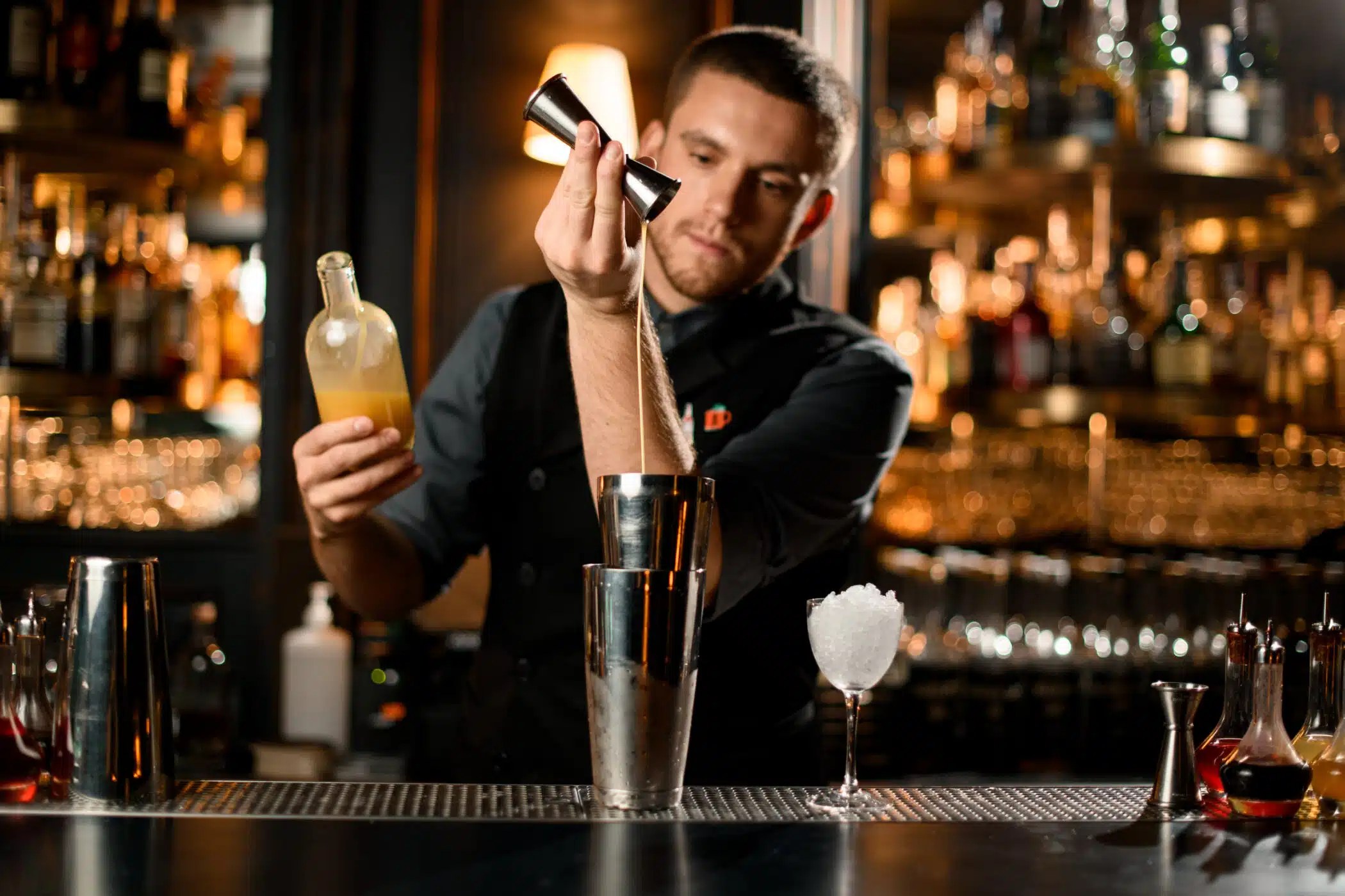 A bartender pouring a cocktail