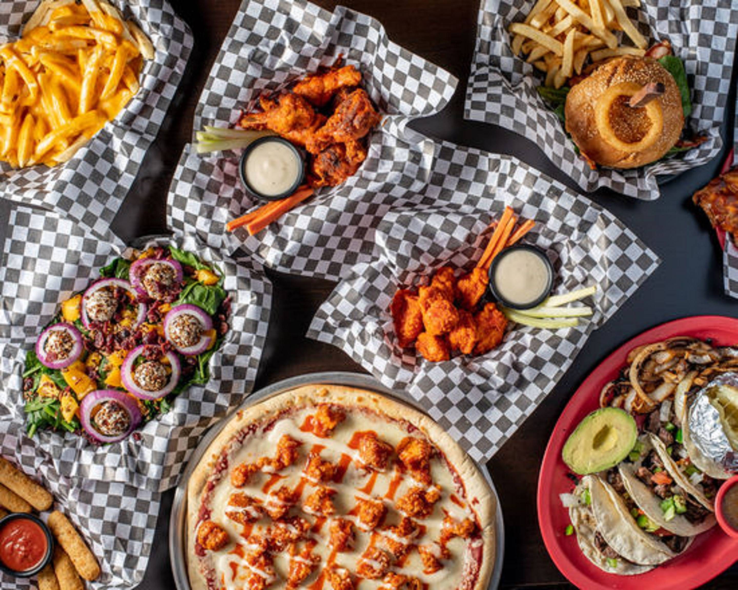 A table of bar food — wings, burgers and fries