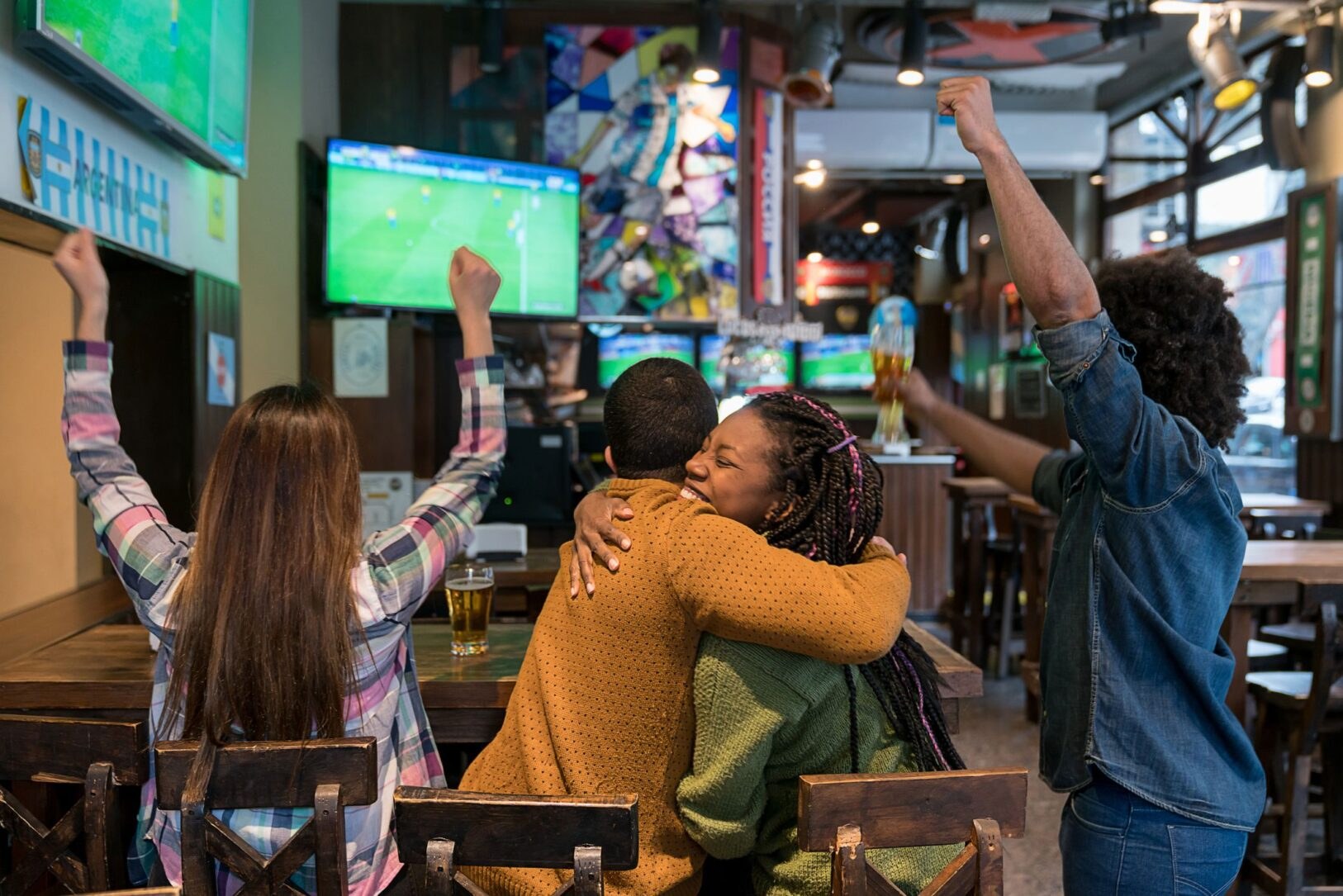 Fans cheering during a big game at the bar